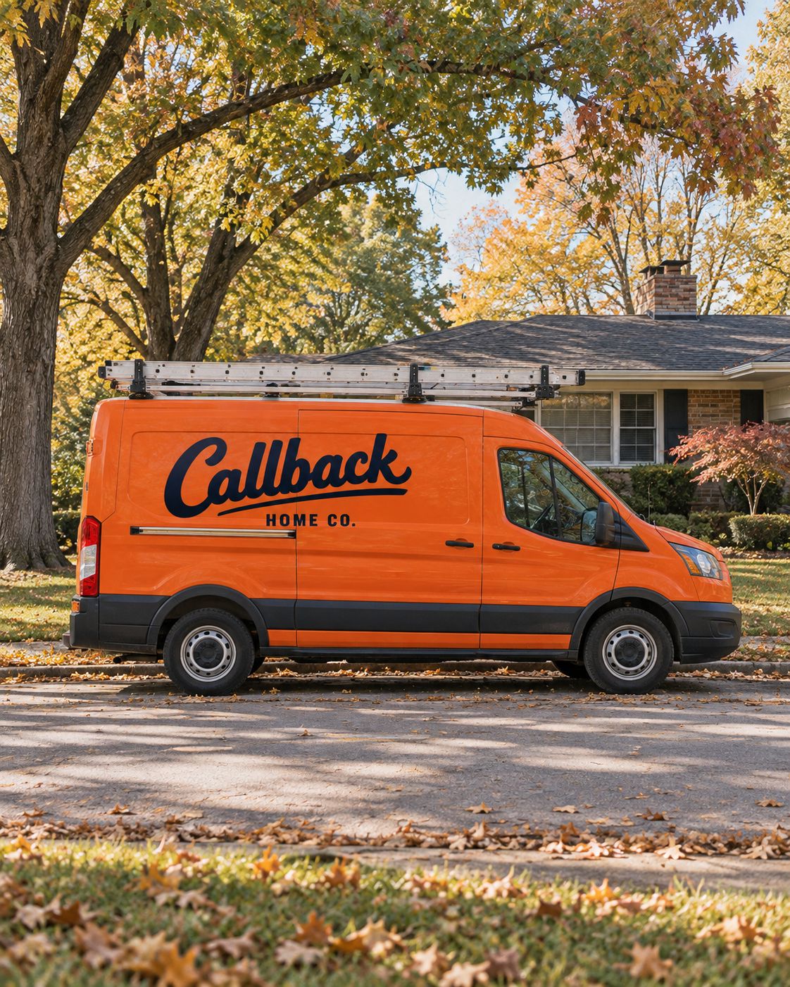 The orange Callback van parked in front of a ranch house in fall